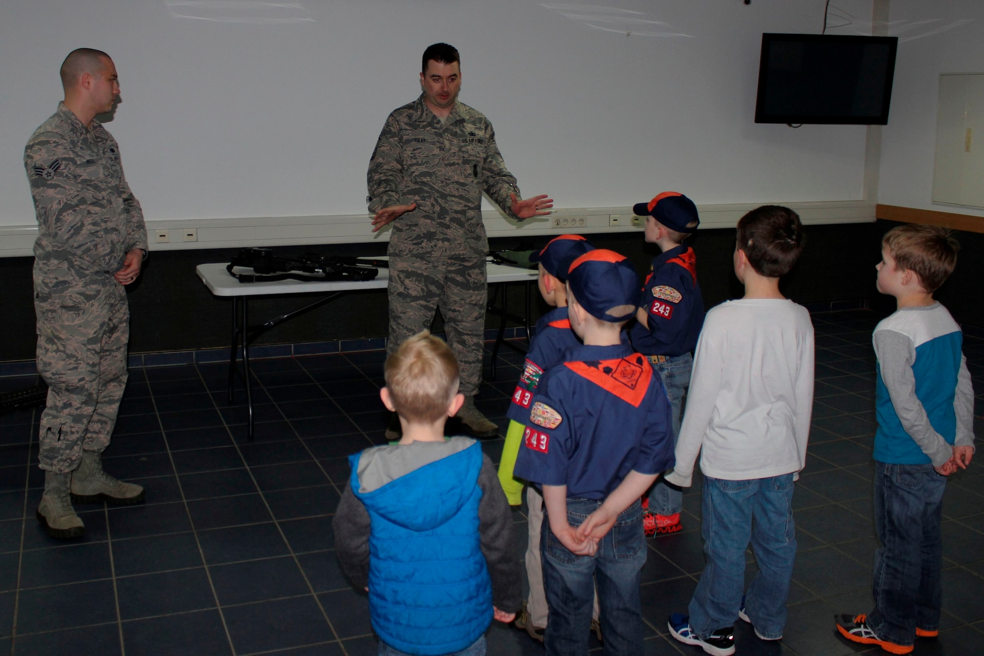 Senior Airman Will Reece, 86th Security Forces Squadron police services assistant and Master Sgt. Gregory Riley, 86th SFS NCO in charge of police services, describe a day in the life of military law enforcement during a Cub Scout visit Feb. 3, 2016, Ramstein Air Base, Germany. Airmen from the 86th SFS gave local Cub Scouts a tour of their facilities and showed them what they do as first responders. (U.S. Air Force photo/Tech. Sgt. Robert A. Webb)