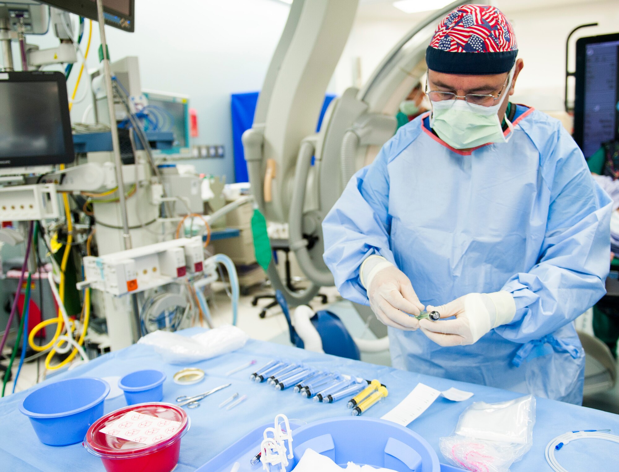 Jesse Aguilar, a 96th Medical Operations Squadron catheter lab technologist, prepares and arranges medical instruments and supplies on a procedure table at Eglin Hospital, Jan. 14 at Eglin Air Force Base, Fla. Aguilar assisted doctors during a cardiac catheterization. Eglin’s newest invasive imaging procedure allows doctors to identify how well a patient’s blood flows to the artery that feeds the heart. (U.S. Air Force photo/Ilka Cole)