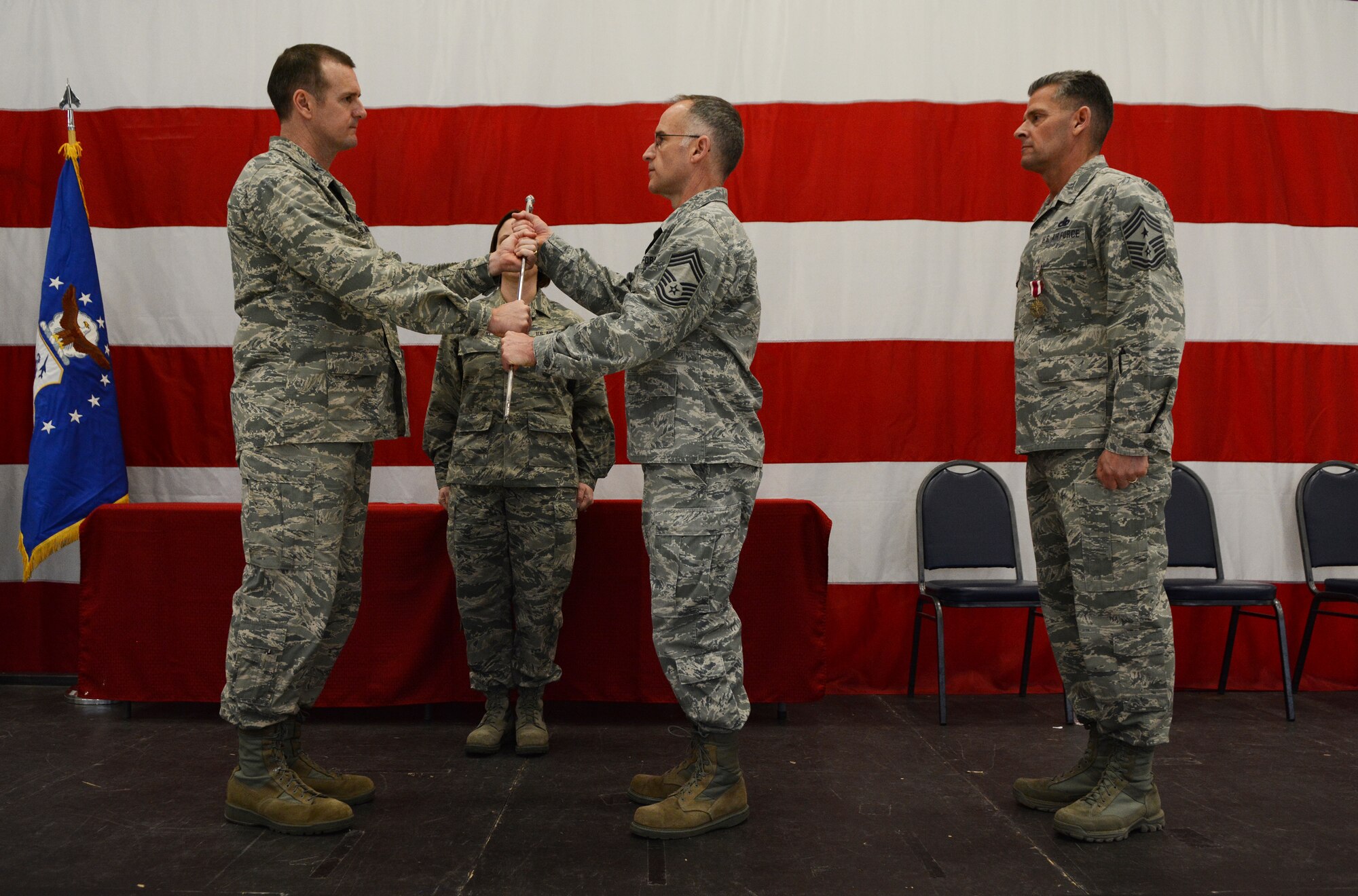 Col. Jeffrey Wiegand, 115th Fighter Wing commander, passes the sword to Chief Master Sgt. James C. McKay, III, 115 FW command chief, during the change of authority ceremony in Hangar 406 Feb. 7, 2016. McKay took over command from Chief Master Sgt. Thomas J. Safer, now the state command chief. (U.S. Air National Guard photo by Senior Airman Kyle Russell)