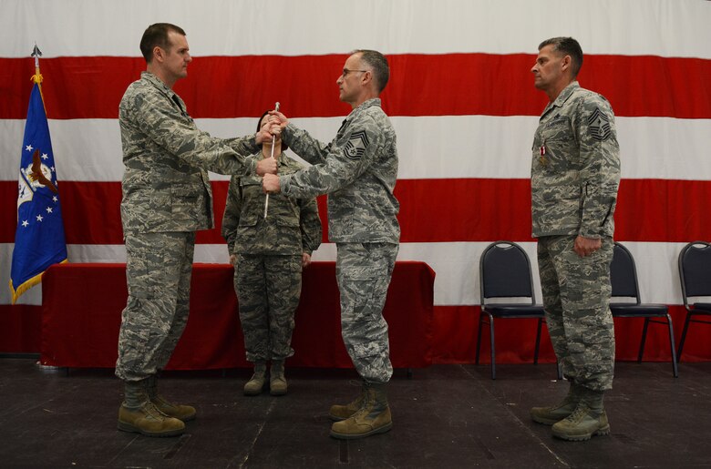 Col. Jeffrey Wiegand, 115th Fighter Wing commander, passes the sword to Chief Master Sgt. James C. McKay, III, 115 FW command chief, during the change of authority ceremony in Hangar 406 Feb. 7, 2016. McKay took over command from Chief Master Sgt. Thomas J. Safer, now the state command chief. (U.S. Air National Guard photo by Senior Airman Kyle Russell)