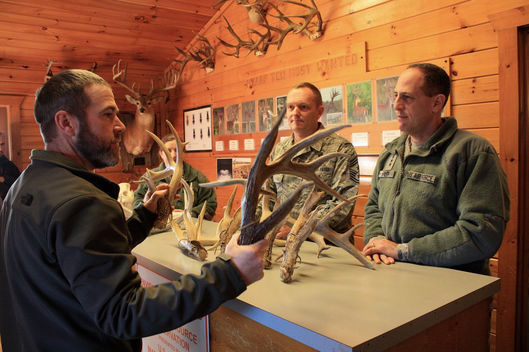 Ryan Toby, chief of the Land Management Office at McAlester Army Ammunition Plant, talks to Lt. Gen. Lee K. Levy II, commander, Air Force Sustainment Center at Tinker Air Force Base, Okla., and Chief Master Sgt. Jason France about the growth of antlers from a large buck on the plant in southeastern Oklahoma during a visit for the base, Jan. 11. (U.S. Army photo by Kevin Jackson)