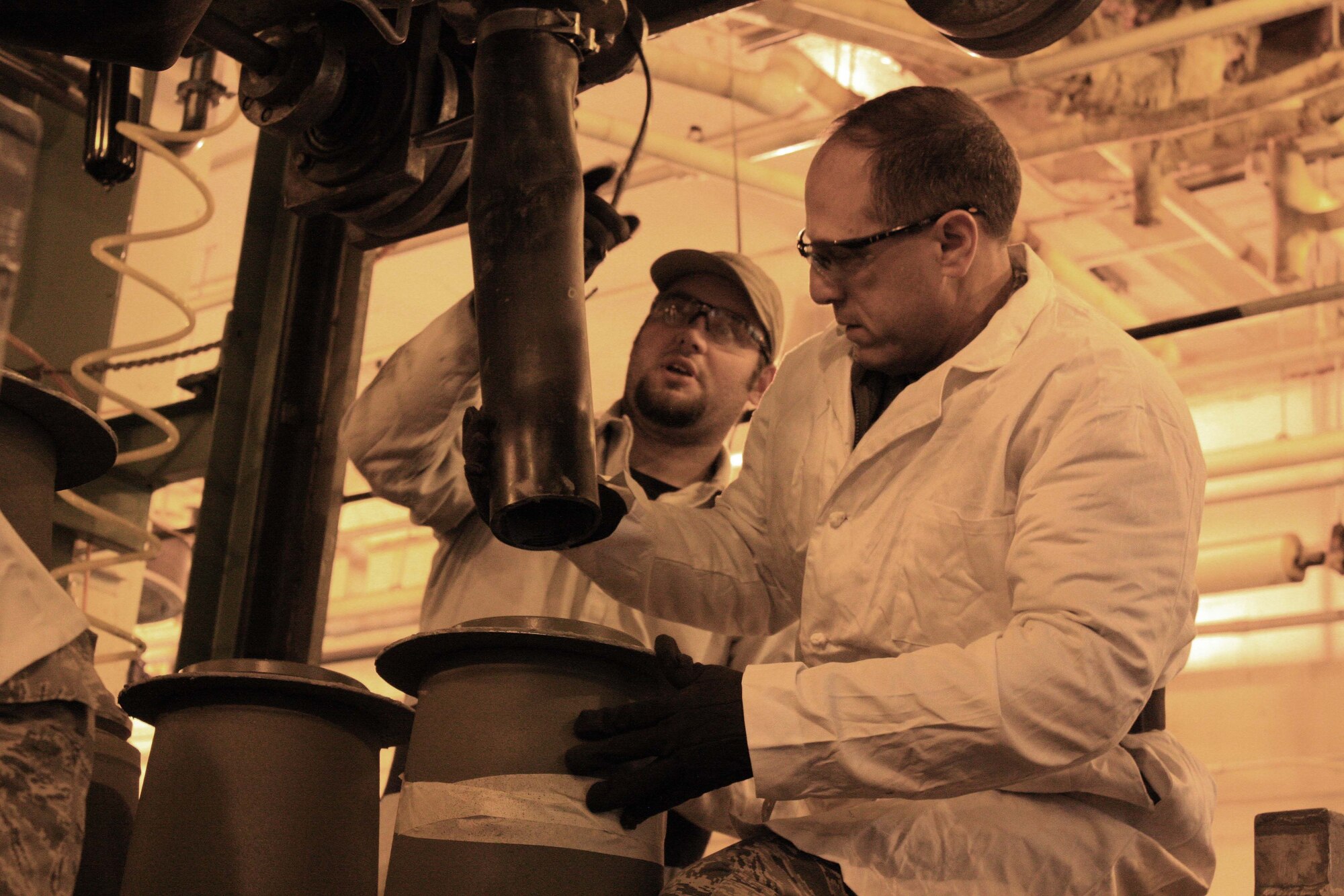 Lt. Gen. Lee K. Levy II (second from left), commander, Air Force Sustainment Center at Tinker Air Force Base, Okla., fills a BLU-111B/B 500-pound, general purpose bomb under the watchful eyes of Garland Seay, an explosives worker at McAlester Army Ammunition Plant, Okla., Jan. 11. (U.S. Army photo by Kevin Jackson)