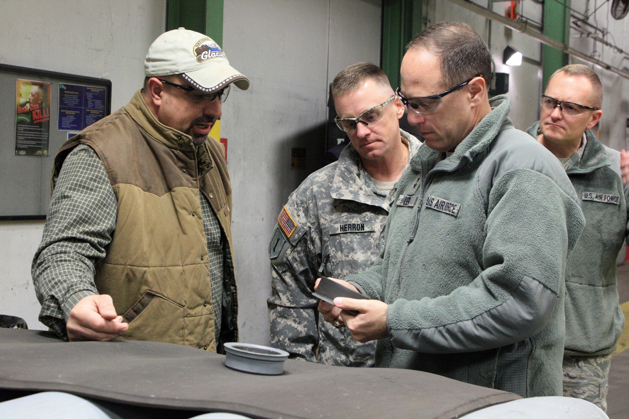 Lt. Gen. Lee K. Levy II, commander, Air Force Sustainment Center at Tinker Air Force Base, Okla., examines a retention ring used on the aft end of a general purpose bomb as Jerry Lovell (far left), Col. Sean M. Herron and Chief Master Sgt. Jason France listen intently.   (U.S. Army photo by Kevin Jackson)