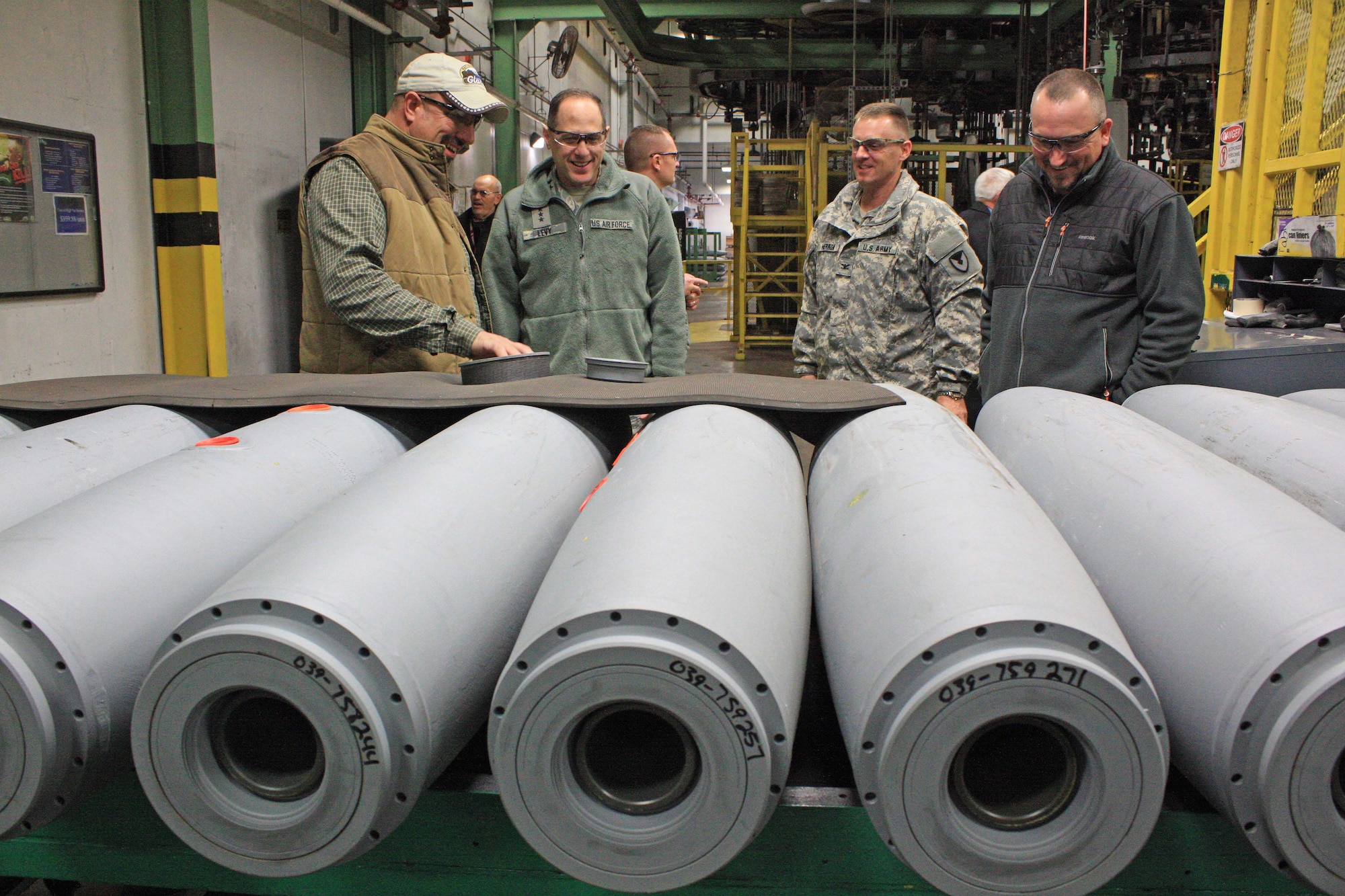 Jerry Lovell (left), A-Line bombs and mines supervisor, talks to Lt. Gen. Lee K. Levy II (second from left), commander, Air Force Sustainment Center at Tinker Air Force Base, Okla., about general purpose bomb preparation during a visit to McAlester Army Ammunition Plant, Okla., Jan. 11. Col. Sean M. Herron, MCAAP commander, and Bill Tollett, director of Ammunition Operations, also listen intently. (U.S. Army photo by Kevin Jackson)