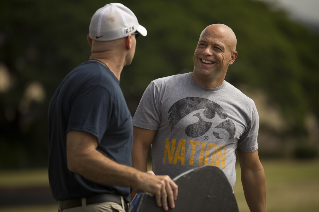 Brad S. Bartelt (right) and Salvatore Cardella chat before a kickball game on Bordelon Field aboard Camp H.M. Smith, Hawaii, Feb. 5, 2016.  Officers and staff noncommissioned officers faced off in a team-building event held quarterly to compete, build camaraderie and increase Esprit de Corps. 
