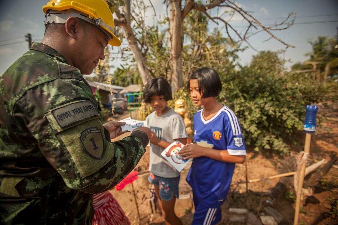 A service member from the Royal Thai Army passes out exercise Cobra Gold 2016 stickers to local Thai civilians in Lop Buri, Thailand, exercise Cobra Gold, Jan. 23, 2016. Cobra Gold 2016, in its 35th iteration, includes a specific focus on humanitarian civic action, community engagement and medical activities conducted during the exercise to support the needs and humanitarian interests of civilian populations around the region. 