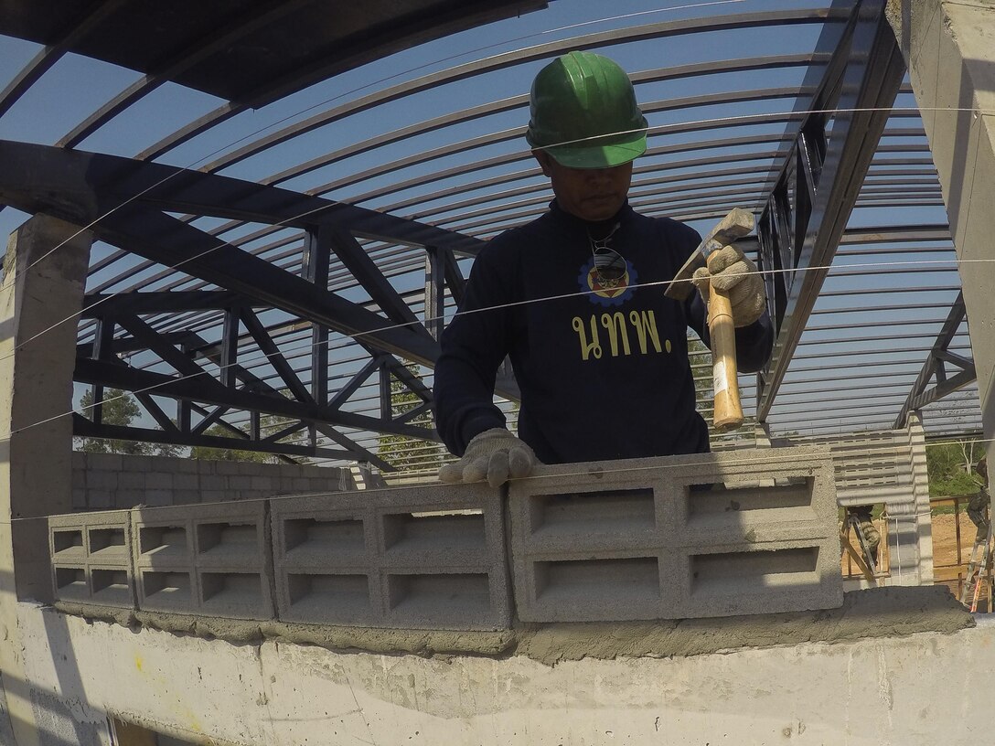 A service member from the Royal Thai Armed Forces helps build a community center at Ban Sa Yai School, in Trat, Thailand, during exercise Cobra Gold, Feb. 3, 2016. Cobra Gold 2016, in its 35th iteration, includes a specific focus on humanitarian civic action, community engagement and medical activities conducted during the exercise to support the needs and humanitarian interests of civilian populations around the region.