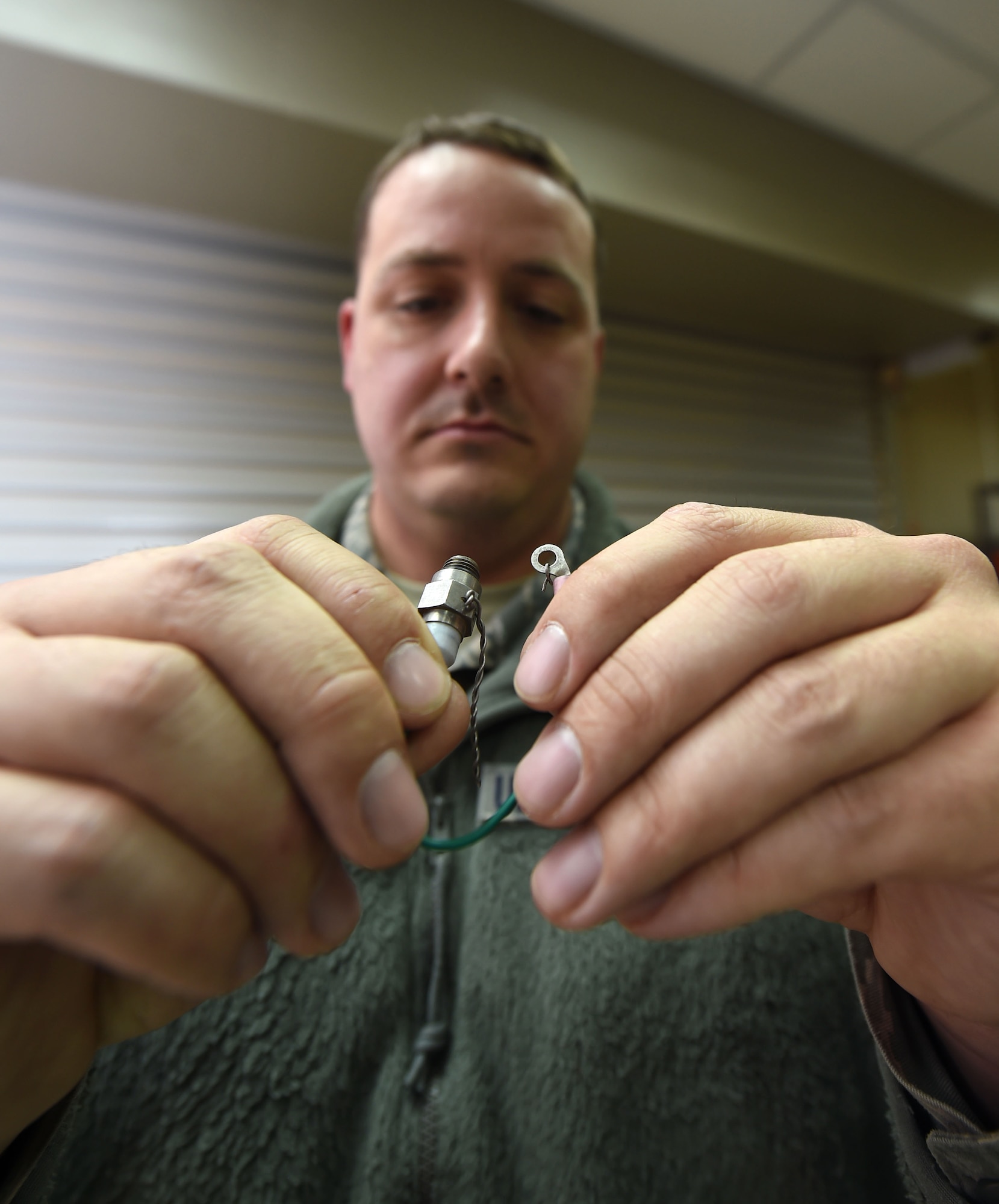 Staff Sgt. Robb King, 386th Munitions Flight munitions inspector, inspects an expended fire bottle cartridge at an undisclosed location in Southwest Asia, Jan. 29, 2016. The munitions flight mission is to test, build and deliver precise munitions to U.S. and coalition aircraft in support of Operation INHERENT RESOLVE. (U.S. Air Force photo by Staff Sgt. Jerilyn Quintanilla)
