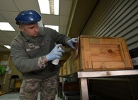 Staff Sgt. James Hurt, 386th Munitions Flight senior munitions inspector, inspects and changes the condition identity on a crate of munitions at an undisclosed location in Southwest Asia, Jan. 29, 2016. The munitions flight mission is to test, build and deliver precise munitions to U.S. and coalition aircraft in support of Operation INHERENT RESOLVE. (U.S. Air Force photo by Staff Sgt. Jerilyn Quintanilla)