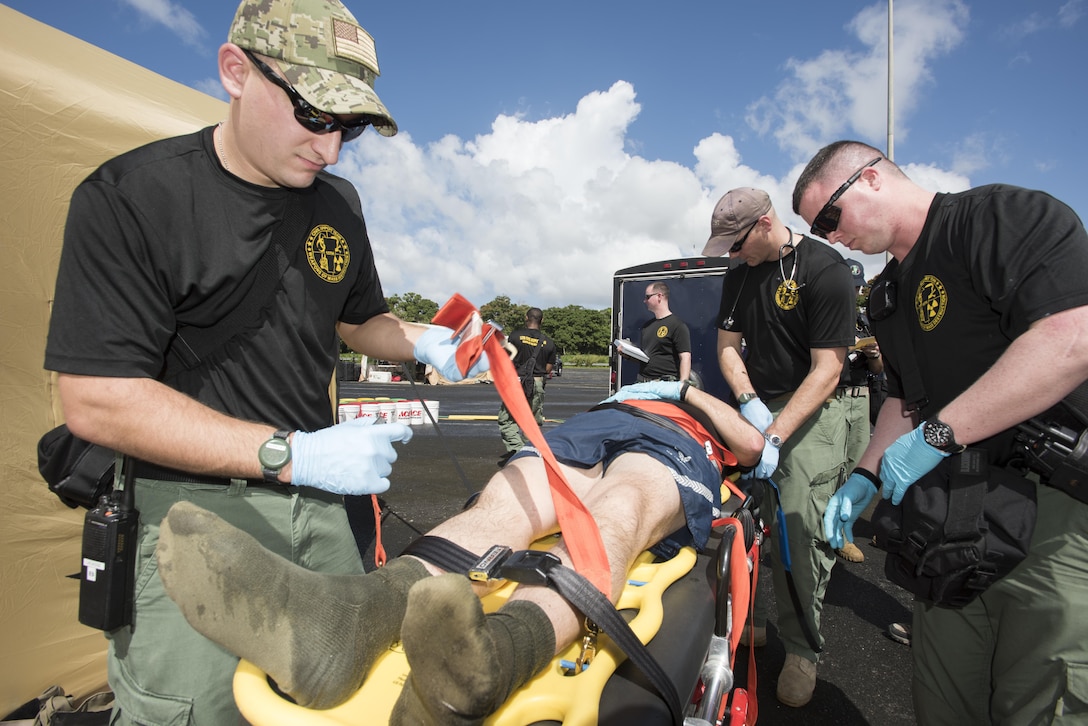 Army Sgt. Josh Lacasse, left, secures Air Force Tech. Sgt. August Hoaglund, center, while Army Sgt. 1st Class Patrick McCabe, right, and Air Force Maj. Michael Korczykowski evaluate the casualty during a simulated man-down drill for the unit’s proficiency training at Roberto Clemente Stadium in Carolina, Puerto Rico, Jan. 26, 2016. Lacasse and Hoaglund are survey team chiefs, McCabe is a medic and Korczykowski is a physician.  They all are assigned to the Vermont National Guard’s 15th Civil Support Team. Vermont Army National Guard photo by Staff Sgt. Nathan Rivard