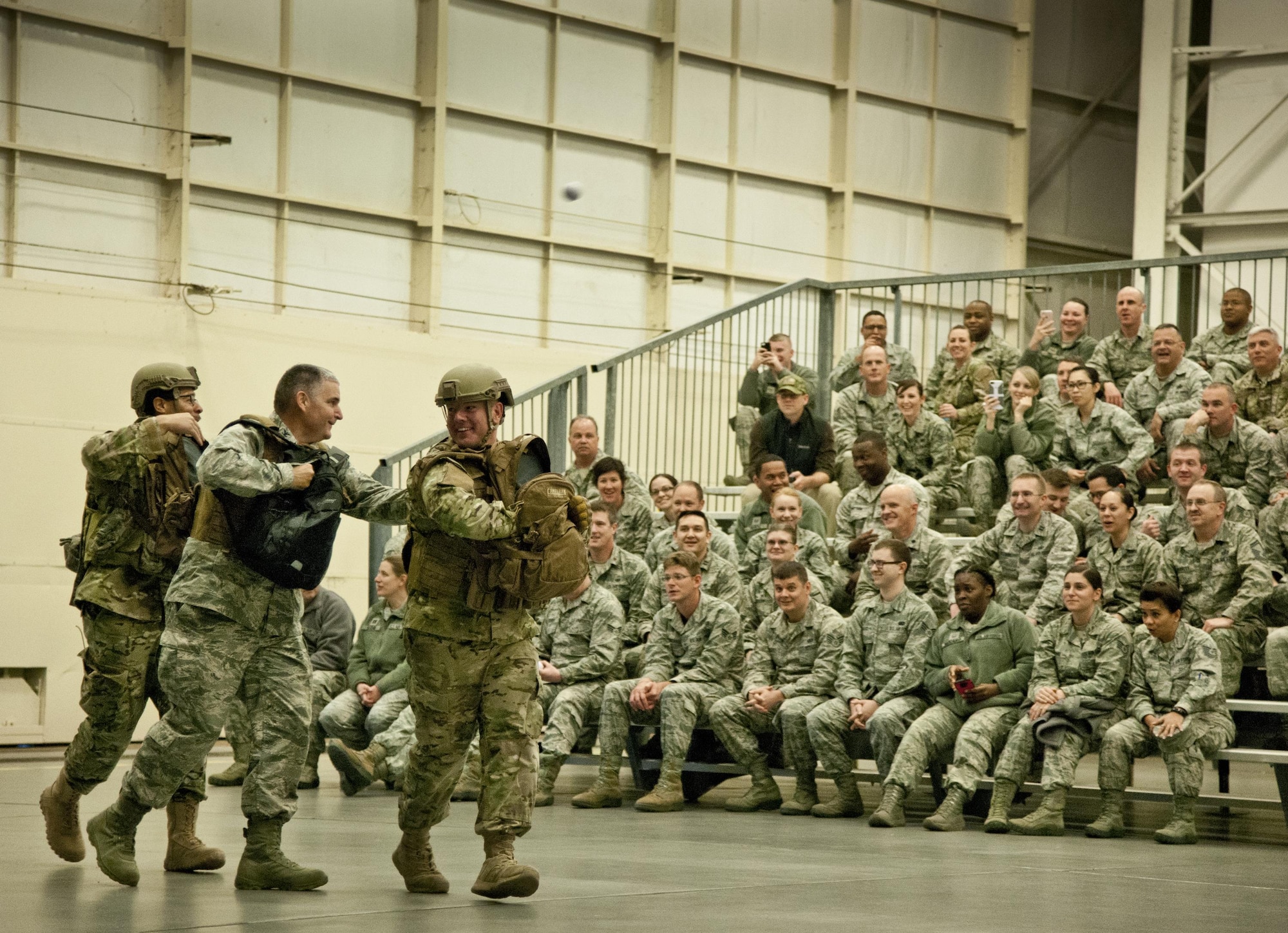 Col. James Phillips, 919th Special Operations Wing commander, makes a grand entrance into the wing’s annual awards ceremony as part of a security forces fire team.  The colonel and his team entered and tossed out stress balls to the Airmen in the crowd on the right side of the room.  Chief Master Sgt. Brian Bischoff, the wing's command chief, did the same with another fire team on the left side to begin the event.  (U.S. Air Force photo/Tech. Sgt. Sam King) 