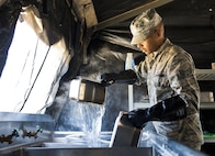 Senior Airman Travis Deese, 919th Special Operations Force Support Squadron, cleans pots and pans in the unit’s field kitchen Feb. 7 at Duke Field Fla.  The kitchen was erected and used as part of the 919th SOFSS flight’s Hennessy Award inspection.  The Airmen cooked and served lunch to customers from the constructed kitchen.  (U.S. Air Force photo/Tech. Sgt. Jasmin Taylor)
