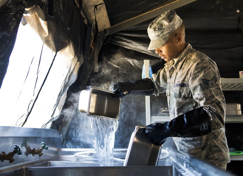 Senior Airman Travis Deese, 919th Special Operations Force Support Squadron, cleans pots and pans in the unit’s field kitchen Feb. 7 at Duke Field Fla.  The kitchen was erected and used as part of the 919th SOFSS flight’s Hennessy Award inspection.  The Airmen cooked and served lunch to customers from the constructed kitchen.  (U.S. Air Force photo/Tech. Sgt. Jasmin Taylor)