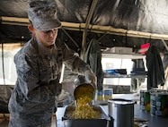 Senior Airman Haylee Jones, 919th Special Operations Force Support Squadron, pours corn into a pan in the unit’s field kitchen Feb. 7 at Duke Field Fla.  The kitchen was erected and used as part of the 919th SOFSS flight’s Hennessy Award inspection.  The Airmen cooked and served lunch to customers from the constructed kitchen.  (U.S. Air Force photo/Tech. Sgt. Jasmin Taylor)