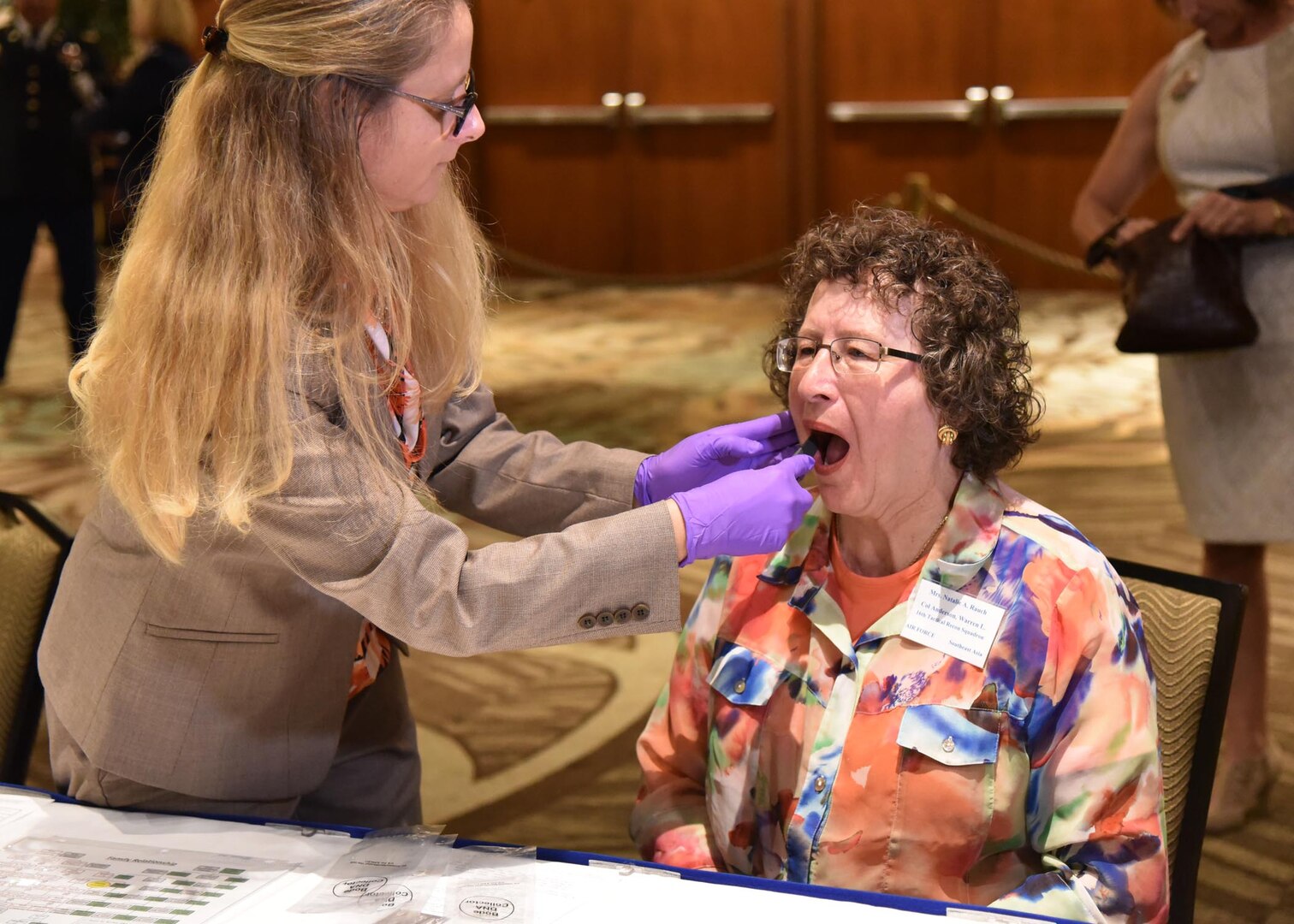 Natalie Anderson Rauch, right, has her cheek swabbed for DNA by Suzanne Barritt-Ross with the Armed Forces DNA Identification Lab, in Honolulu, Jan. 25.  Rauch’s father went missing in the Vietnam War.  In case his remains are ever located, they may be identified through the DNA sample she provided.
