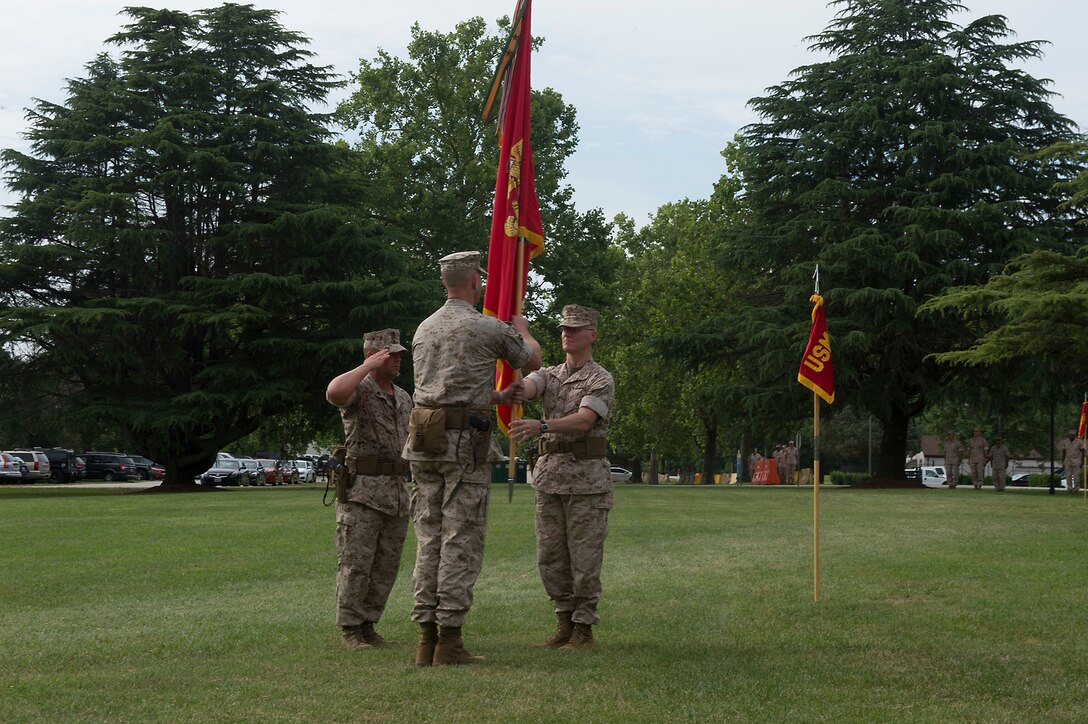 U.S. Marine Col. James M. Bright, the outgoing commanding officer of the Marine Corps Security Force Regiment, passes the regimental colors to incoming regimental commanding officer, U.S. Marine Col. John W. Evans, during the change-of-command ceremony June 19 at Naval Weapons Station Yorktown, Va. The exchanging of regimental colors represents the passing of command from the outgoing to the incoming commanding officer.