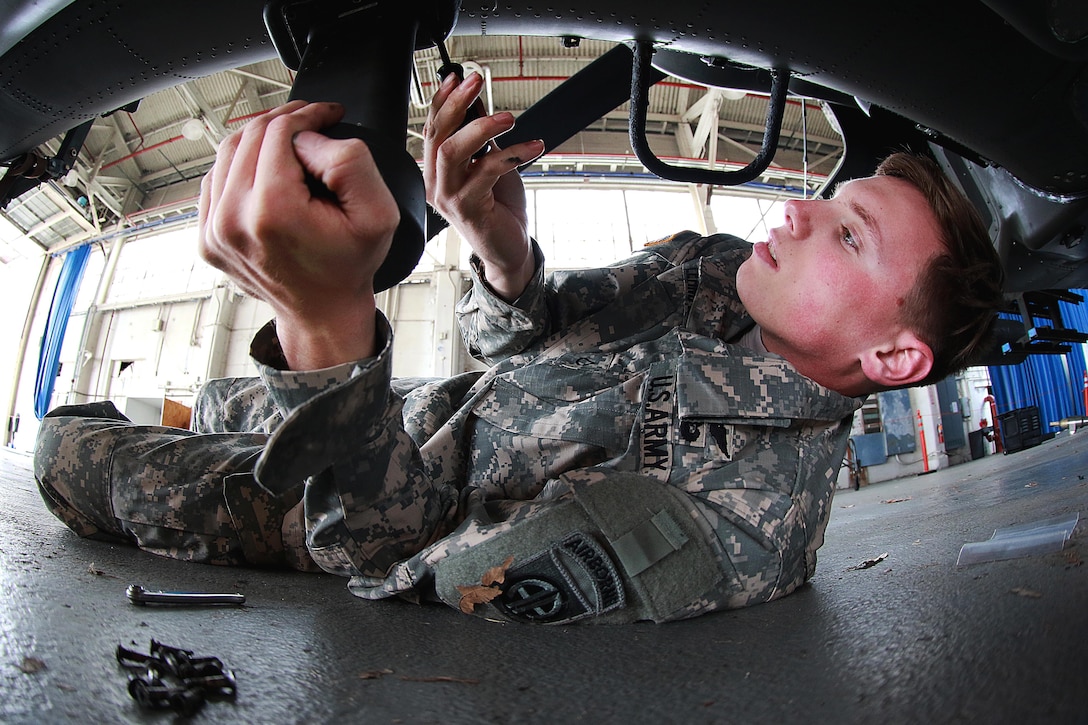 A soldier prepares an AH-64 Apache helicopter for transport at Fort Bragg, N.C., Feb. 2, 2016. Army photo by Staff Sgt. Christopher Freeman