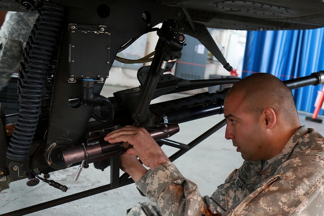 A soldier removes a portion of a weapon system while preparing an AH-64 Apache helicopter for transport at Fort Bragg, N.C., Feb. 2, 2016. Army photo by Staff Sgt. Christopher Freeman