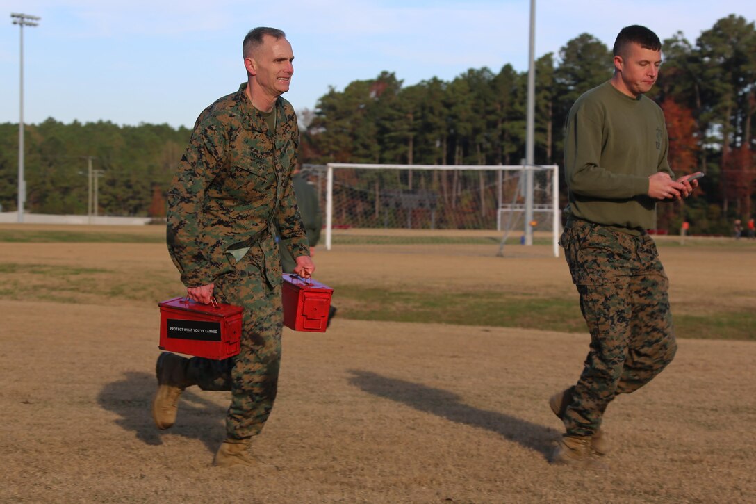 The 2nd Marine Aircraft Wing Commanding General, Maj. Gen. Gary Thomas carries ammunition cans through the maneuver under fire course as he is timed by Cpl. Ethan Mussaw during a combat fitness test at Marine Corps Air Station Cherry Point, N.C., Dec. 4, 2015. The CFT is an annual requirement for all Marines to assess their physical capacity in a broad spectrum of combat-related tasks. 2nd MAW Marines maintain their combat readiness year-round in order to provide continuous support to the Marine Air-Ground Task Force. Thomas is the commanding general of 2nd MAW and Mussaw is an operations clerk with Marine Wing Headquarters Squadron 2. (U.S. Marine Corps photo by Cpl. N.W. Huertas/Released)