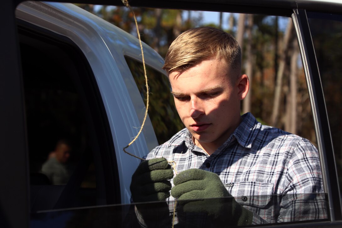 Lance Cpl. Jonah Merkle ties a tree to a vehicle during the 10th annual trees for troops event at Marine Corps Air Station Cherry Point, N.C., Dec. 8, 2015. More than 400 free trees were distributed to service members and their families as a symbol of brotherhood and appreciation from the community during the holiday season. Merkle is a bulk fuel specialist with Marine Wing Support Squadron 274. (U.S. Marine Corps photo by Cpl. N.W. Huertas/Released)