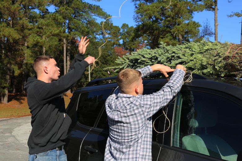 Marines tie a tree to the roof of a car during the 10th annual trees for troops event at Marine Corps Air Station Cherry Point, N.C., Dec. 8, 2015. More than 400 free trees were distributed to service members and their families as a symbol of brotherhood and appreciation from the community during the holiday season. (U.S. Marine Corps photo by Cpl. N.W. Huertas/Released)