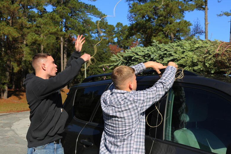 Marines tie a tree to the roof of a car during the 10th annual trees for troops event at Marine Corps Air Station Cherry Point, N.C., Dec. 8, 2015. More than 400 free trees were distributed to service members and their families as a symbol of brotherhood and appreciation from the community during the holiday season. (U.S. Marine Corps photo by Cpl. N.W. Huertas/Released)