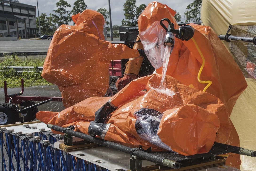 Army Staff Sgt. Rusty Greeno, right, rinses Air Force Tech. Sgt. August Hoaglund during decontamination for a man-down drill during proficiency training at Roberto Clemente Stadium in Carolina, Puerto Rico, Jan. 26, 2016. Greeno and Hoaglund are survey team chiefs assigned to the Vermont National Guard’s 15th Civil Support Team. Vermont Army National Guard photo by Staff Sgt. Nathan Rivard