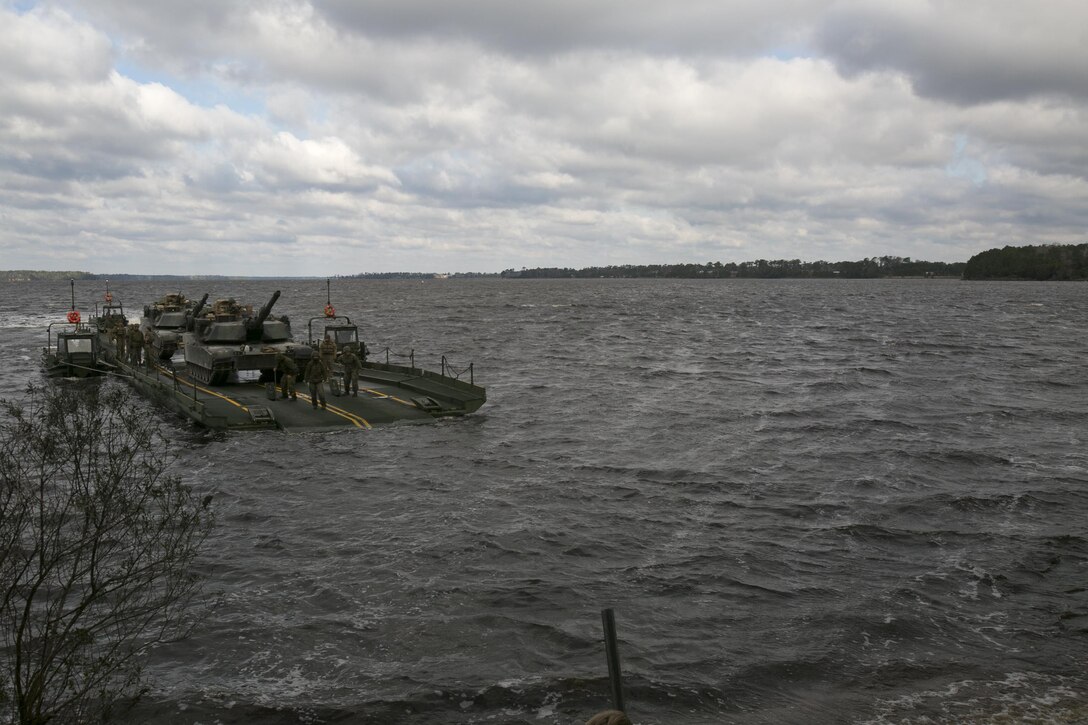Marines with Bridge Company, 8th Engineer Support Battalion, transport two M1A1 Abrams tanks across New River, using a seven-bay raft system during a water-crossing operation at Camp Lejeune, N.C., Feb. 4, 2016. The unit provides support to any unit across the II Marine Expeditionary Force that needs to cross any body of water regardless of size. (U.S. Marine Corps photo by Lance Cpl. Damarko Bones/Released)