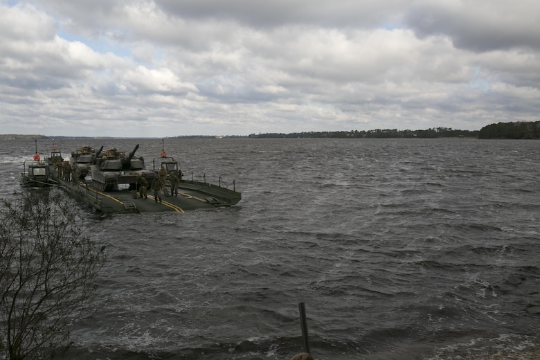 Marines with Bridge Company, 8th Engineer Support Battalion, transport two M1A1 Abrams tanks across New River, using a seven-bay raft system during a water-crossing operation at Camp Lejeune, N.C., Feb. 4, 2016. The unit provides support to any unit across the II Marine Expeditionary Force that needs to cross any body of water regardless of size. (U.S. Marine Corps photo by Lance Cpl. Damarko Bones/Released)
