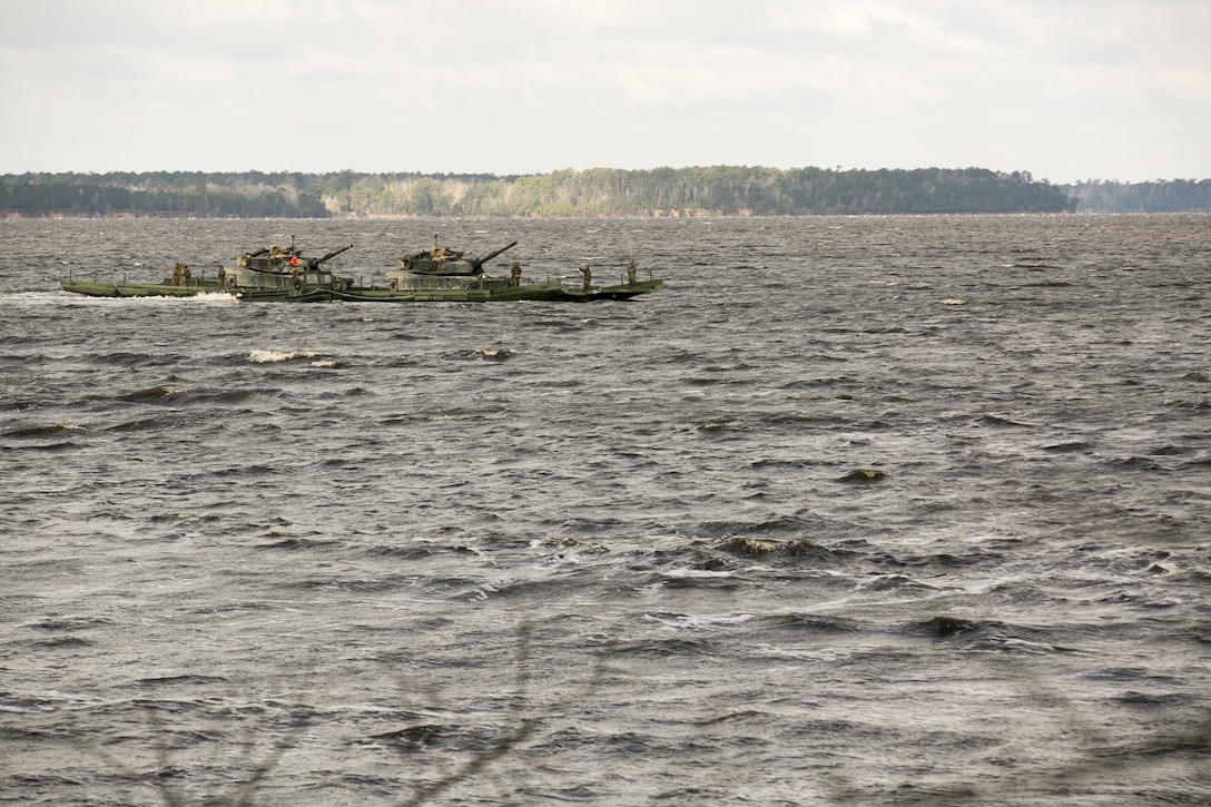 Marines with Bridge Company, 8th Engineer Support Battalion, transport two M1A1 Abrams tanks across New River, using a seven-bay raft system during a water-crossing operation at Camp Lejeune, N.C., Feb. 4, 2016. The raft increases mobility of tactical vehicles by allowing the vehicles to cross any body of water regardless of size. (U.S. Marine Corps photo by Lance Cpl. Damarko Bones/Released)