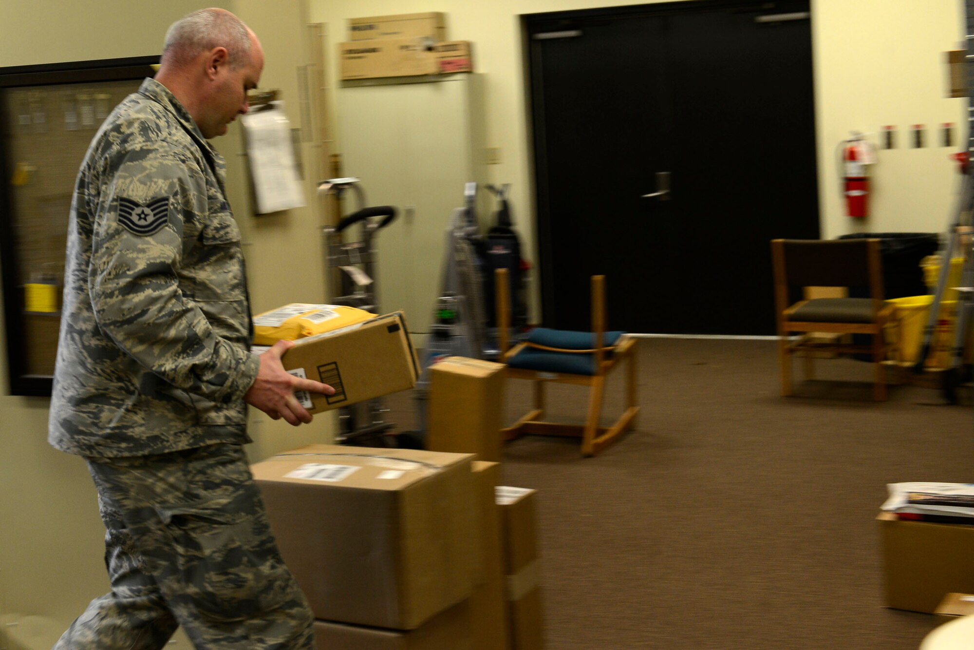 U.S. Air Force Tech. Sgt. Casey Ames, 20th Civil Engineer Squadron Airmen dormitory leader, carries a package into the dorm management building at Shaw Air Force Base, S.C., Jan. 21, 2016. Dorm management takes in all UPS and FedEx orders that dorm Airmen receive and allocate them once signed for at the front desk. (U.S. Air Force photo by Airman 1st Class Christopher Maldonado)