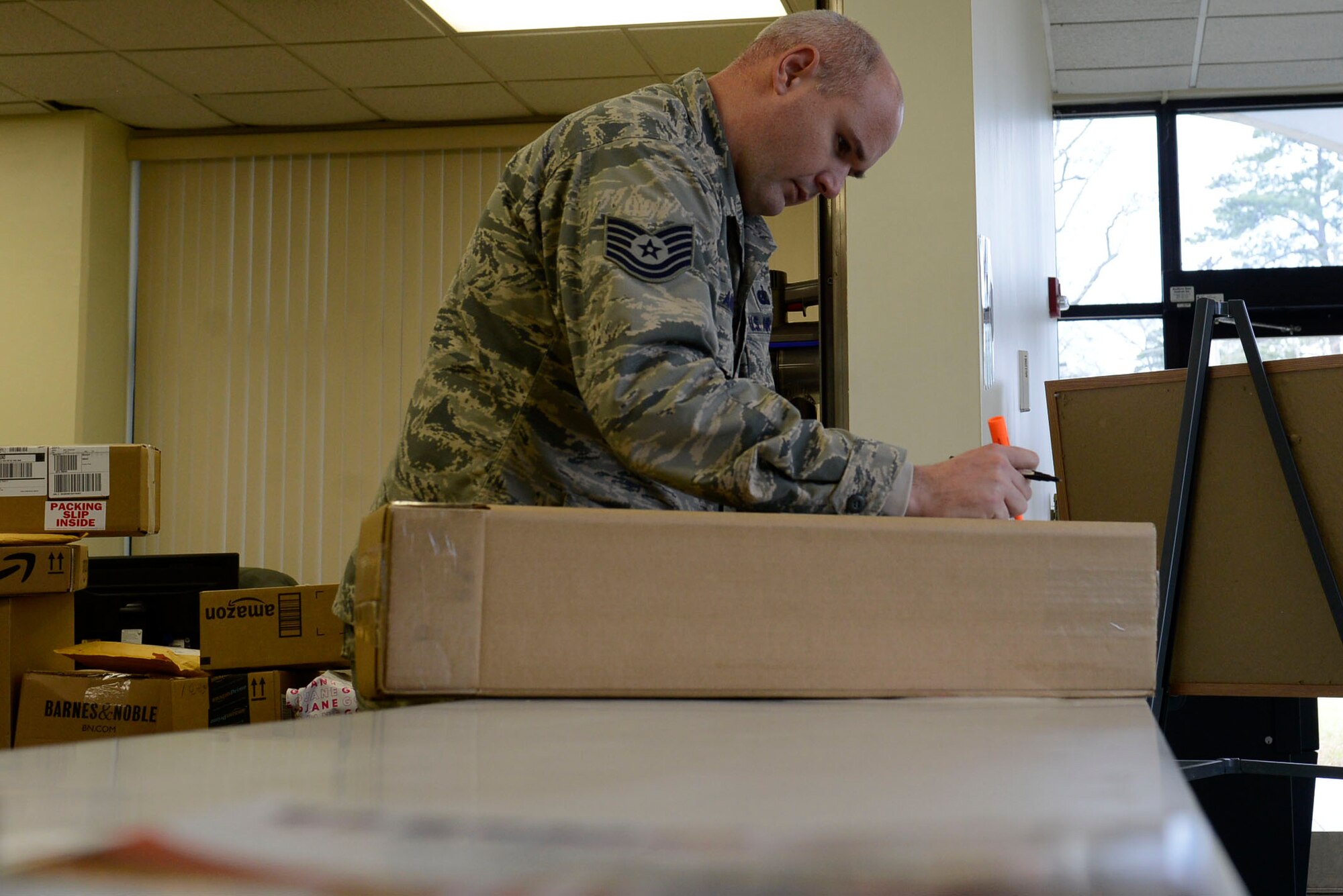 U.S. Air Force Tech. Sgt. Casey Ames, 20th Civil Engineer Squadron Airmen dormitory leader, marks a package as delivered at Shaw Air Force Base, S.C., Jan. 21, 2016. Dorm management aids approximately 630 Airmen by providing appliance repairs and mentoring, as well as a secure location to collect packages. (U.S. Air Force photo by Airman 1st Class Christopher Maldonado)