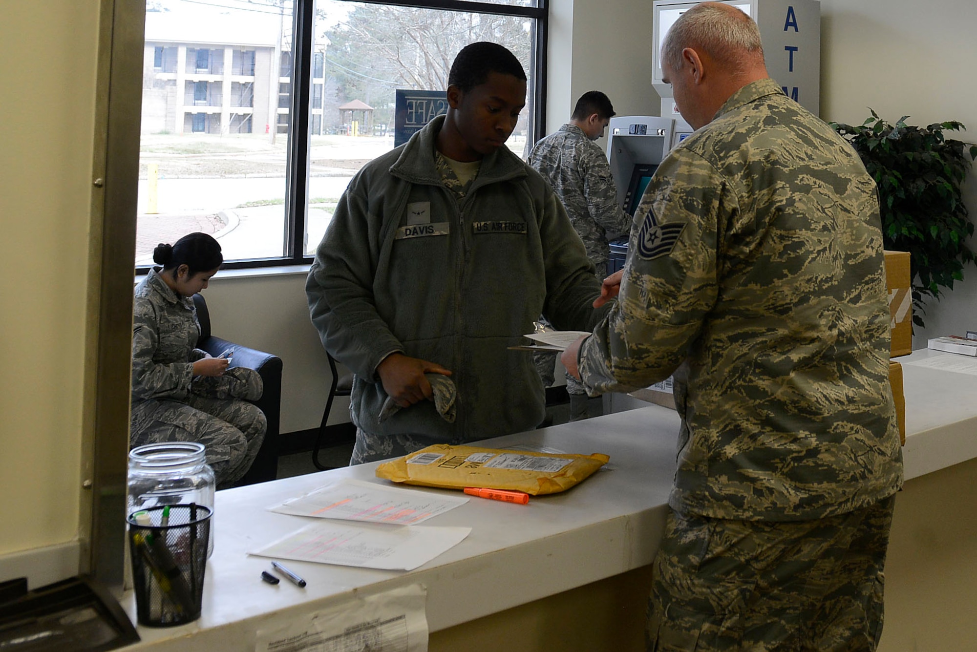 U.S. Air Force Tech. Sgt. Casey Ames, 20th Civil Engineer Squadron Airmen dormitory leader, hands a new Airman in-processing paperwork at Shaw Air Force Base, S.C., Jan. 21, 2016. Dorm management ensures that new Airmen have proper living arrangements upon arrival to Shaw. (U.S. Air Force photo by Airman 1st Class Christopher Maldonado)