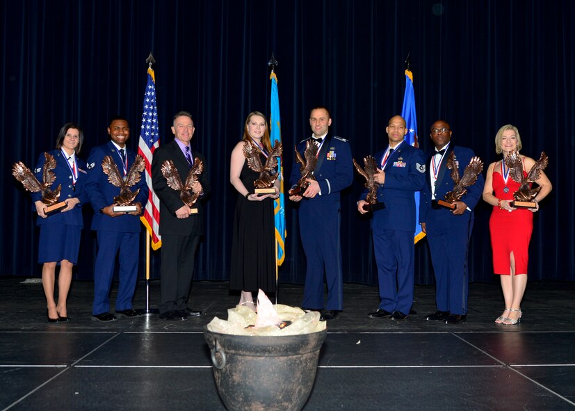 From left, Senior Airman Ashlin Federick, 436th Airlift Wing Public Affairs community relations specialist, Senior Airman Dequan Vann, 436th Medical Support Squadron pharmacy technician, John Walters, 436th Force Support Squadron fitness program manager, Jill Eaves, 436th Aircraft Maintenance Squadron key spouse, Capt. Andrew McFee, 436th AW protocol chief, Tech. Sgt. Antwan Piper, 436th FSS Man power and organization NCO in charge, Master Sgt. Montrell Jones, 436th FSS first sergeant, and Stephanie Harrison, 3d Airlift Squadron administrative and financial resource advisor, pose for a group photo with their annual awards trophy 2015 436th Airlift Wing Annual Awards Ceremony Jan. 5, 2016, at the Rollins Center in Dover, Del. These award winners will now compete at the Air Mobility Command level for their respected categories. (U.S. Air Force photo/Senior Airman William Johnson)