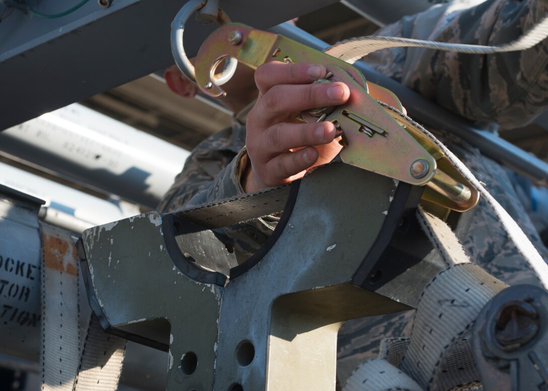 U.S. Air Force Airman 1st Class Julian Lopez III, weapons crew member assigned to the 94th Aircraft Maintenance Squadron, loosens a tie-down strap at Langley Air Force Base, Va., Feb. 2, 2016. The “94th Banner Ops” event is a three-day event that features the 94th AMU loading munitions for F-22A Raptor pilots’ weapon proficiency training. (U.S. Air Force photo by Staff Sgt. J.D. Strong II/Released)