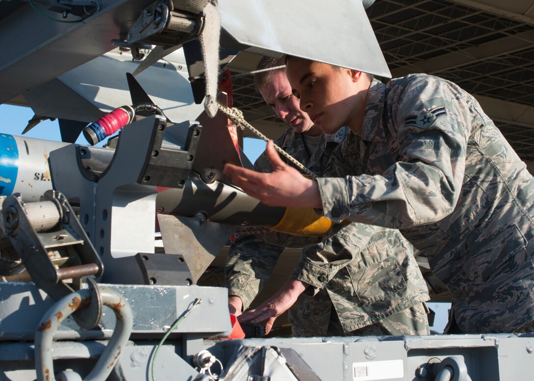 U.S. Air Force Tech. Sgt. Michael Dickens and Airman 1st Class Julian Lopez III, weapons crew members assigned to the 94th Aircraft Maintenance Squadron, prepare to move an AIM-9 sidewinder missile at Langley Air Force Base, Va., Feb. 2, 2016. Dickens and Lopez started the “94th Banner Ops” event with their weapons load. (U.S. Air Force photo by Staff Sgt. J.D. Strong II/Released)