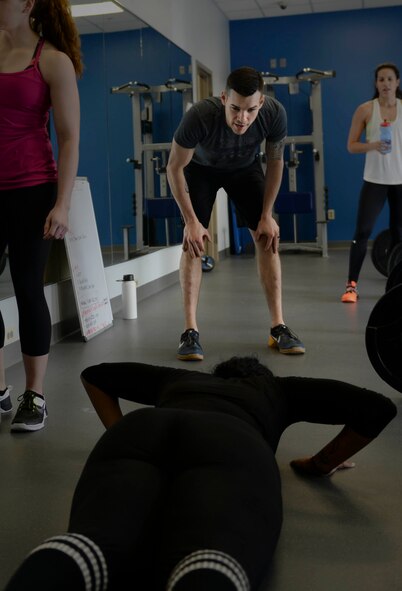 Volunteer coach Tech. Sgt. Kyle Douglass, a flight chief assigned to the 91st Missile Security Forces Squadron, motivates an athlete in the beginner’s tactical fitness class, OnRamp, at the McAdoo Fitness Center Feb. 4, 2016. OnRamp focuses on form and mechanics for athletes with no prior tactical fitness experience. (U.S. Air Force photo/Airman 1st Class Jessica Weissman)