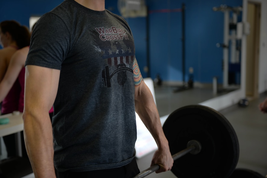 Volunteer coach Tech. Sgt. Kyle Douglass, a flight chief assigned to the 91st Missile Security Forces Squadron, demonstrates the proper hand grip for a dead-lift at the McAdoo Fitness Center Feb. 4, 2016. Douglass is one of nine volunteer coaches for the newly offered tactical fitness class. (U.S. Air Force photo/Airman 1st Class Jessica Weissman)