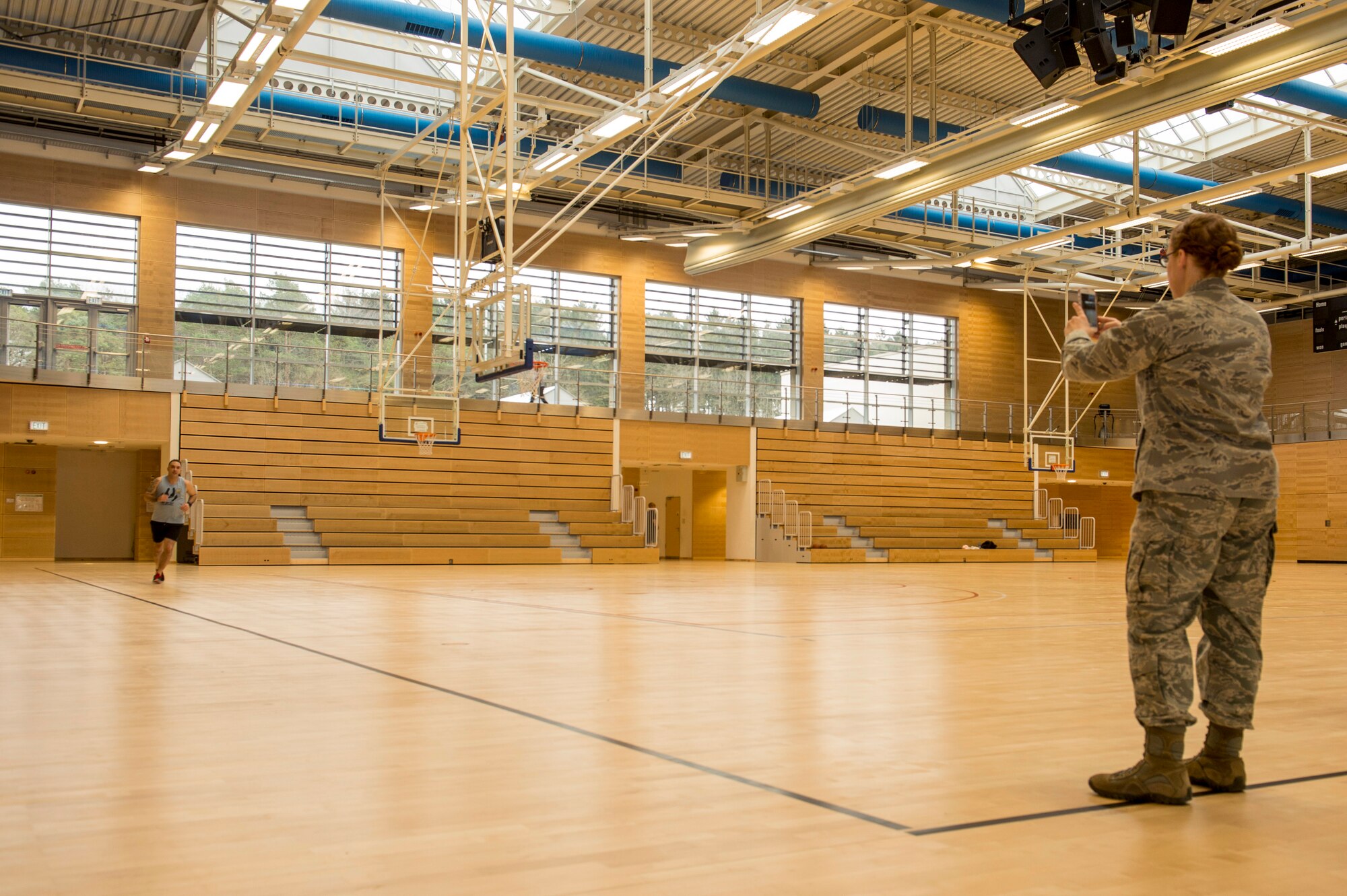 U.S. Air Force Maj. Tisha Sutton, 52nd Medical Operations Squadron medical services flight commander and physical therapist, monitors a Spangdahlem Airman during a running clinic inside the George Price Gymnasium Feb. 5, 2016. Sutton offered tips on how to improve running ability as a part of the clinic. (U.S. Air Force photo by Senior Airman Rusty Frank/Released)