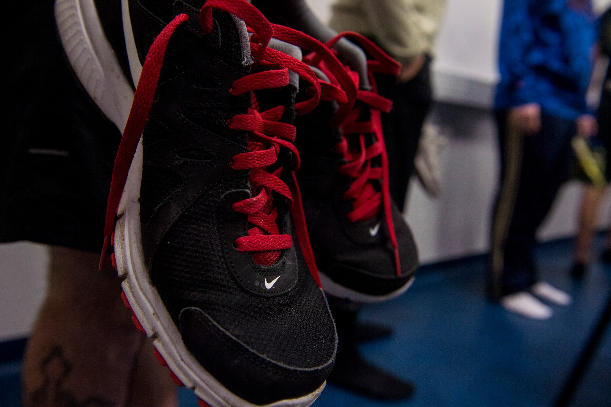 A Spangdahlem Airman holds his shoes while waiting to have his feet measured during a running clinic inside the Eifel Powerhaus Feb. 5, 2016, at Spangdahlem Air Base, Germany. Airmen received foot measurements, instruction on how to improve their running style and safety tips during the clinic. (U.S. Air Force photo by Senior Airman Rusty Frank/Released)