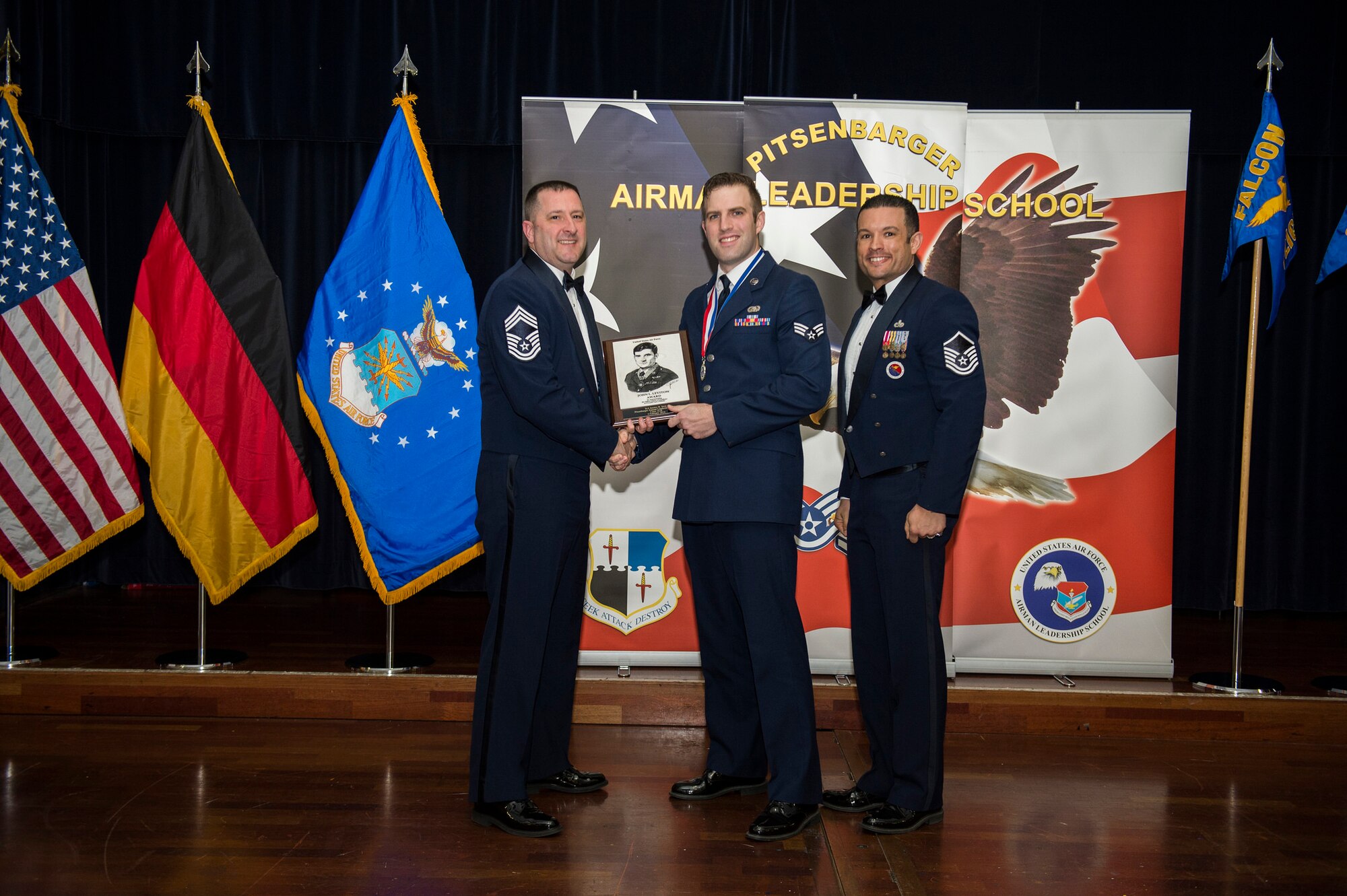 U.S. Air Force Chief Master Sgt. Richard Lukens, 52nd Equipment Maintenance Squadron superintendent, left, and U.S. Air Force Master Sgt. Roberto Oregon, Pitsenbarger Airman Leadership School commandant, right, present U.S. Air Force Senior Airman Jeremy Smit, 52nd Communications Squadron, center, with the John L. Levitow award during the ALS Class 16-B graduation ceremony at Club Eifel on Spangdahlem Air Base, Germany, Feb. 6, 2016. The Levitow award is presented to the student who demonstrated the most outstanding leadership and scholastic qualities based on academic performance and assignment of points by peers and instructors. (U.S. Air Force photo by Airman 1st Class Luke Kitterman/Released)
