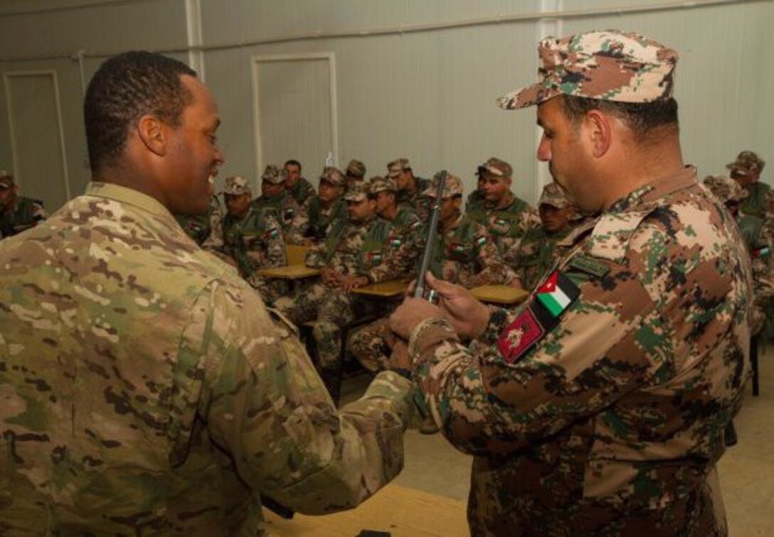 Spc. Reshard Coley gets some assistance from Sgt. Mohamad Miselh, an instructor with the Jordanian Border Guard, disassembling an M60 machine gun during a combined training exercise at the Jordanian Border Guard School, Jordan, Jan. 17. (U.S. Army photo by Sgt. Youtoy Martin, 19th Public Affairs Detachment)