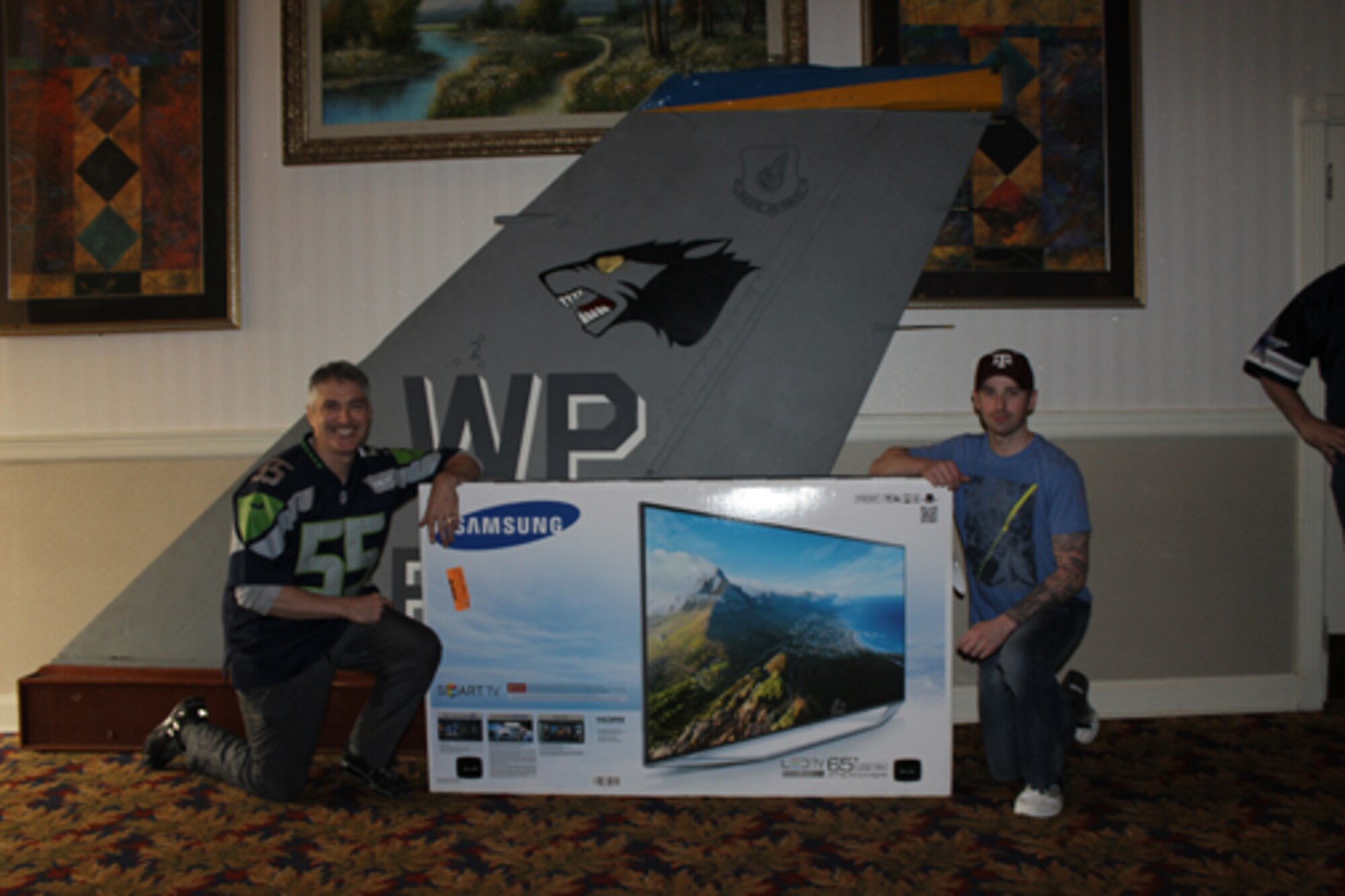 Tech. Sgt. Thomas Waters, 8th Mission Support Group resource advisor, right, poses with Col. Jeremy Sloane, 8th Fighter Wing commander, Monday Feb. 8 during the Super Bowl celebration at the Loring Club on Kunsan Air Base,
Republic of Korea. Waters won the grand prize of a 65 inch smart TV, courtesy of the Air Force's College Football Championship Program contest, in the award announced Monday. (Photo courtesy of 8th Force Support Squadron/Released) 
