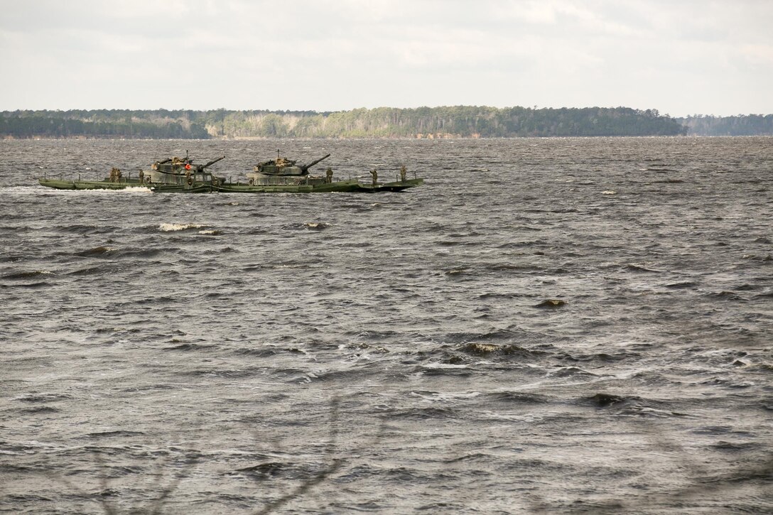 Marines with Bridge Company, 8th Engineer Support Battalion, transport two M1A1 Abrams tanks across New River, using a seven-bay raft system during a water-crossing operation at Marine Corps Base Camp Lejeune, N.C., Feb. 4, 2016. The raft increases mobility of tactical vehicles by allowing the vehicles to cross any body of water regardless of size. 