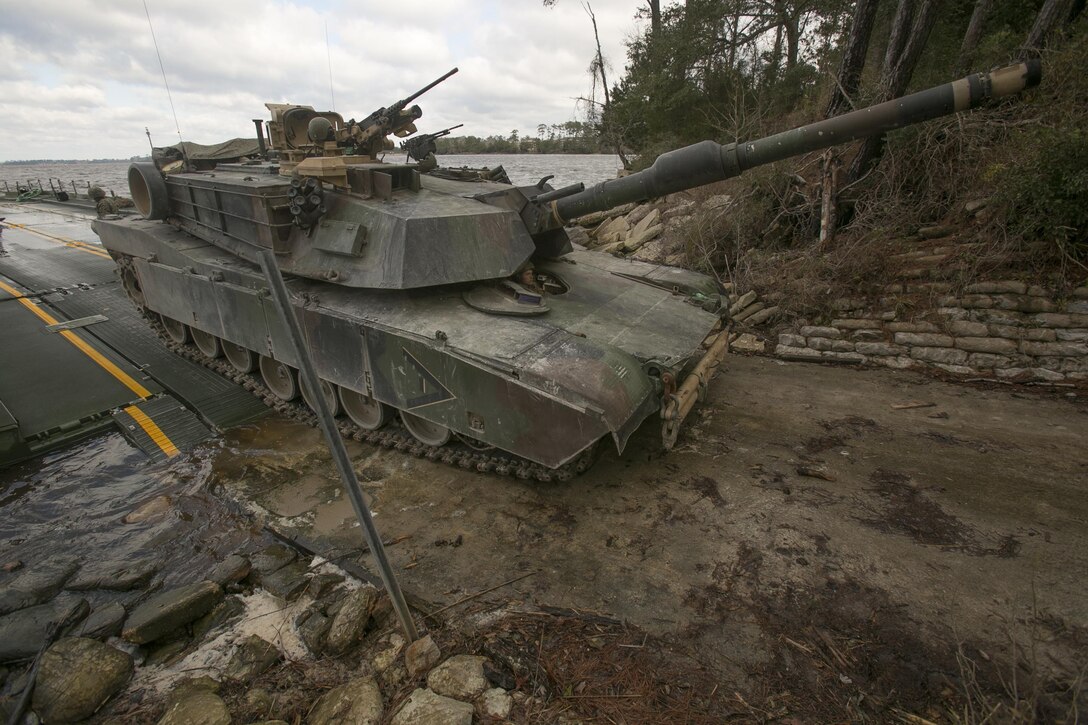 Marines with Bridge Company, 8th Engineer Support Battalion, roll an M1A1 Abrams tank off of a seven-bay raft system after being transported across New River during a water-crossing operation at Marine Corps Base Camp Lejeune, N.C., Feb. 4, 2016. The unit boasts a wide range of raft systems and bridging that it is able to do to allow tactical vehicles to cross large bodies of water. 