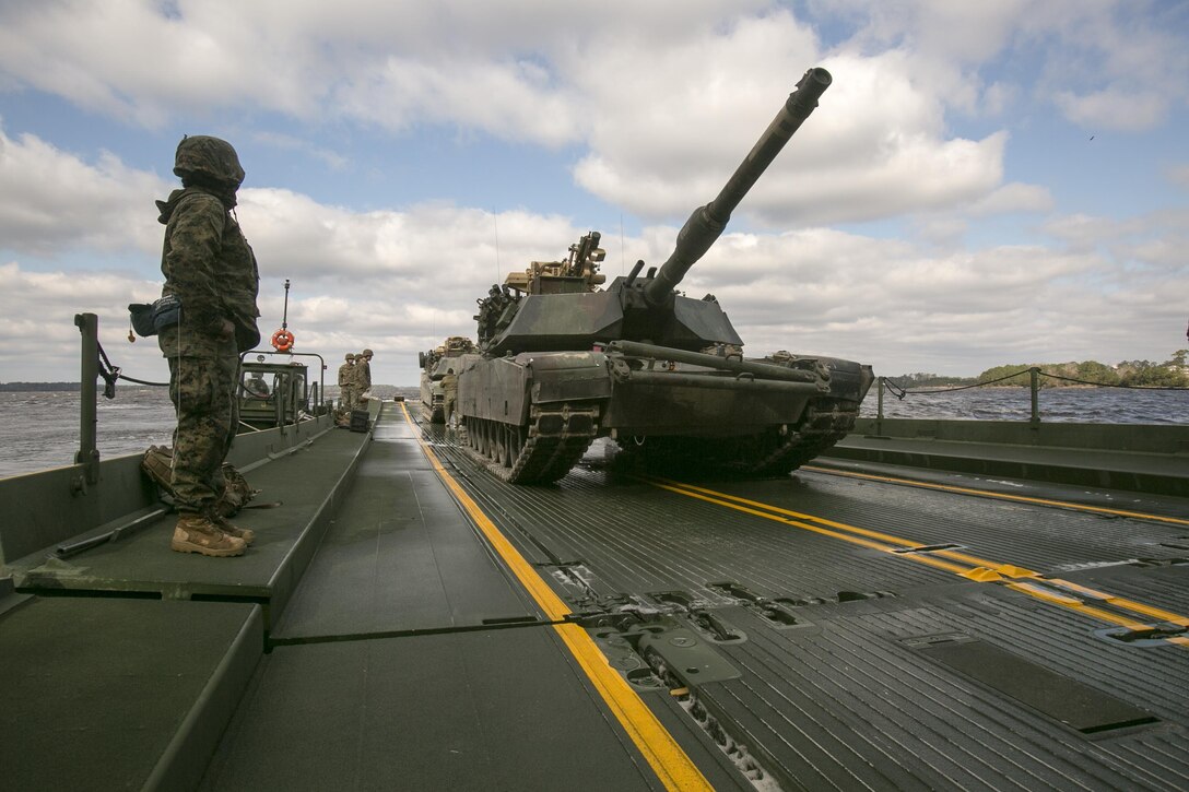 Marines with Bridge Company, 8th Engineer Support Battalion, prepare to unload two M1A1 Abrams tanks following their transport across New River by using a seven-bay raft system during a water-crossing operation at Marine Corps base Camp Lejeune, N.C., Feb. 4, 2016. The unit boasts a wide range of raft systems and bridging that it is able to do to allow tactical vehicles to cross large bodies of water.