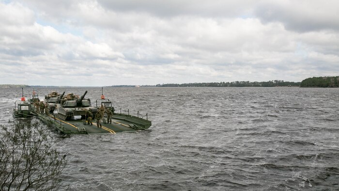 Marines with Bridge Company, 8th Engineer Support Battalion, transport two M1A1 Abrams tanks across New River, using a seven-bay raft system during a water-crossing operation at Marine Corps Base Camp Lejeune, N.C., Feb. 4, 2016. The unit provides support to any unit across the II Marine Expeditionary Force that needs to cross any body of water regardless of size. 