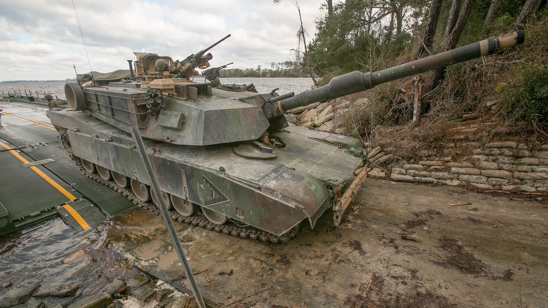 Marines with Bridge Company, 8th Engineer Support Battalion, roll an M1A1 Abrams tank off of a seven-bay raft system after being transported across New River during a water-crossing operation at Marine Corps Base Camp Lejeune, N.C., Feb. 4, 2016. The unit boasts a wide range of raft systems and bridging that it is able to do to allow tactical vehicles to cross large bodies of water. 