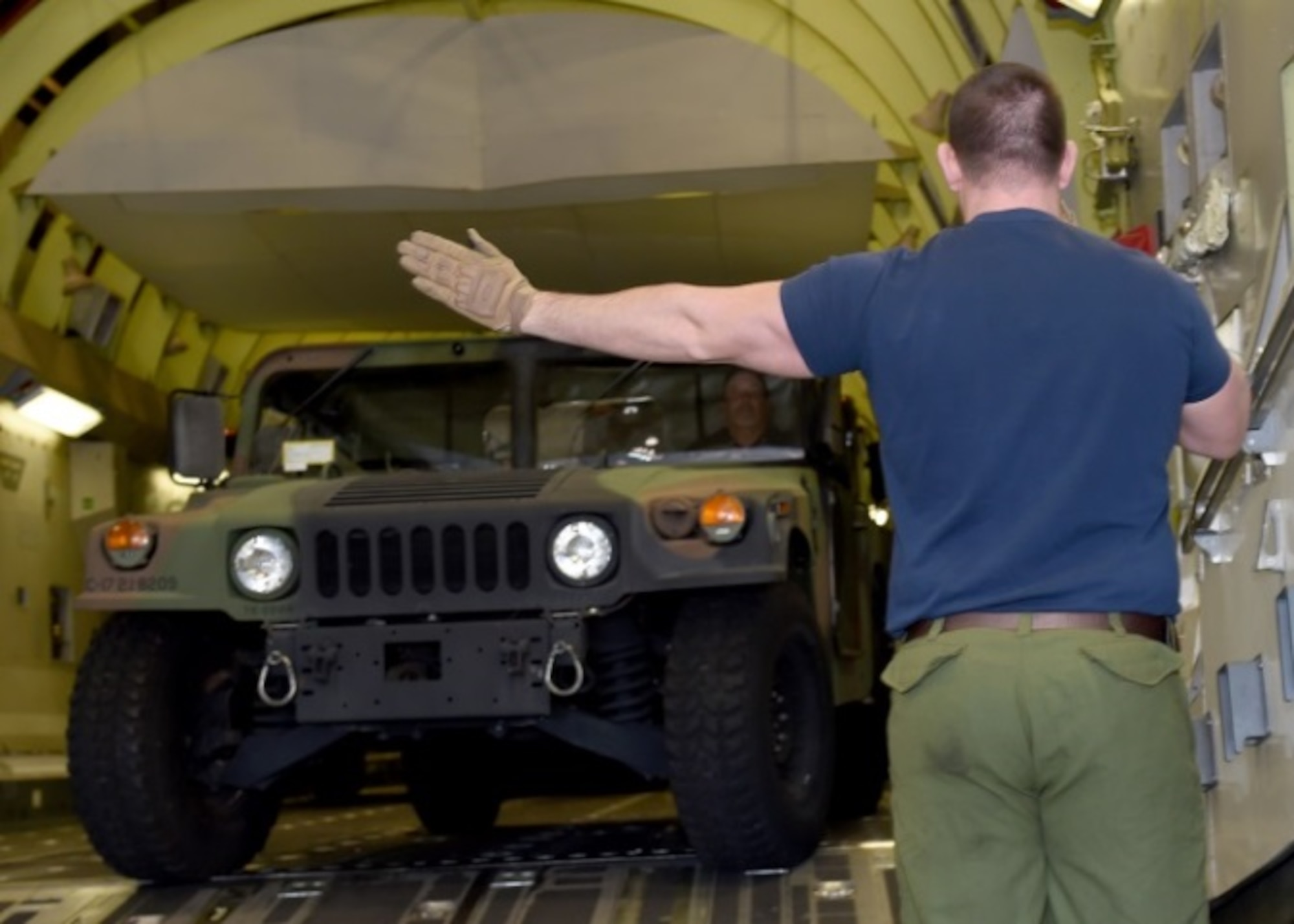 Royal Canadian air force Master Corporal Derek Bristol, C-17 Globemaster III cargo aircraft loadmaster trainee, directs a Humvee off a C-17 cargo simulator, Altus Air Force Base, Okla., Dec. 16, 2015. Training international students helps improve joint nation missions with uniformed knowledge and operations. (U.S. Air Force photo by Airman 1st Class Kirby Turbak/Released)