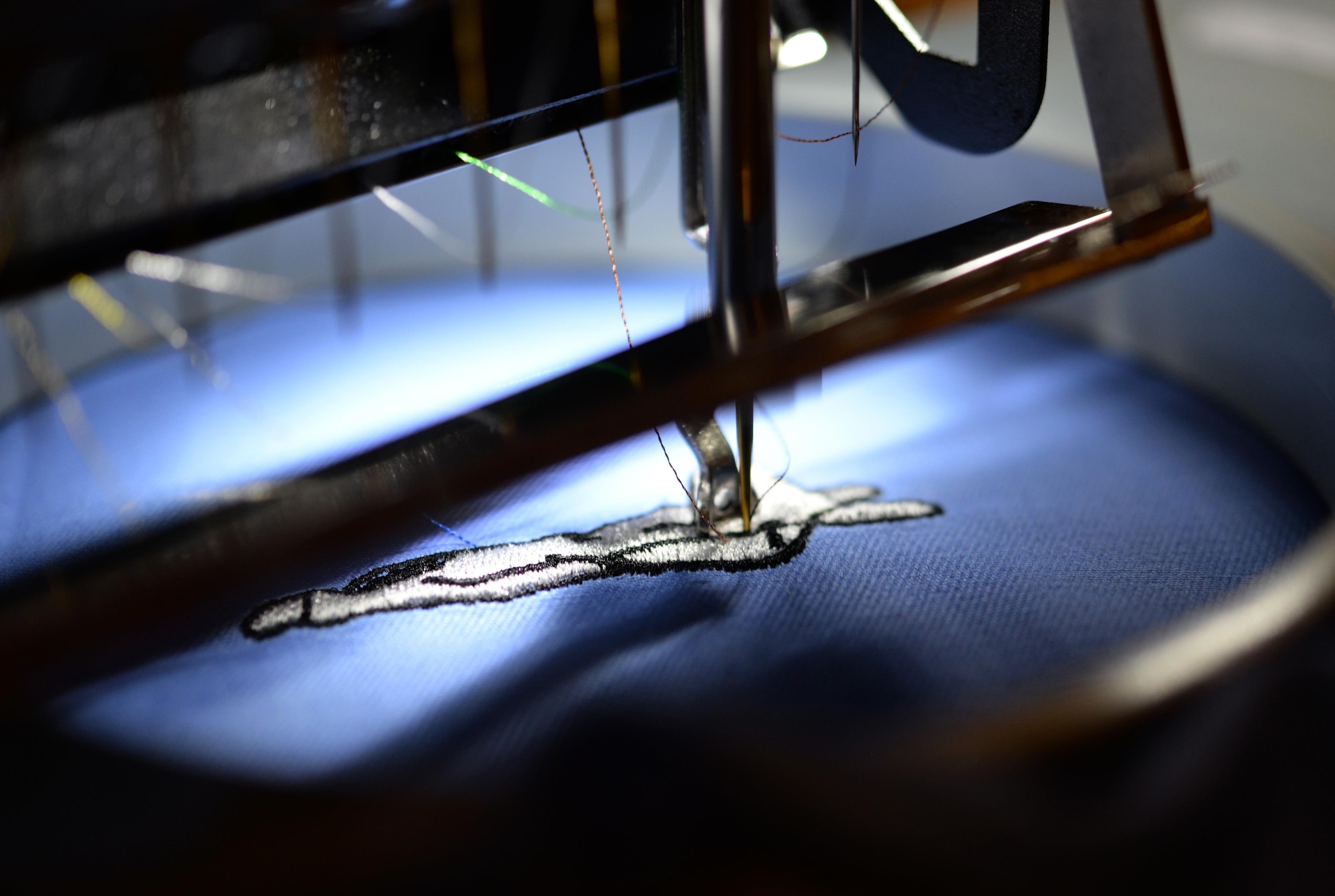 The Arts and Crafts Center’s embroidery machine sews an F-22 Raptor on a piece of cloth Feb. 2, 2016, Keesler Air Force Base, Miss. The embroidery shop is a newly opened segment of the Arts and Crafts Center that embroiders everything from baby clothes to name tapes. (U.S. Air Force photo by Airman 1st Class Travis Beihl)